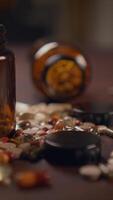 There are scattered pills and a medicine bottle resting on the table in disarray video
