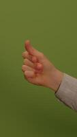 A thumbs up gesture on a vibrant green background, symbolizing approval and positivity video