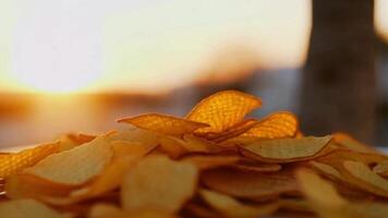 a pile of chips on a table with the sun setting in the background video