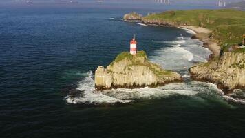 Basargin Lighthouse on a rocky island with a suspension bridge to it. Drone view video