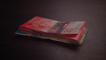 A Stack of Colorful Banknotes Arranged Neatly on a Dark Surface for Visual Appeal video