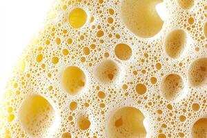 Close-up of yellow bubble texture with large and small circles in foam structure photo