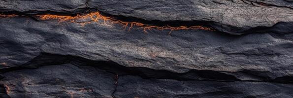 Volcanic rock surface with glowing lava cracks in natural landscape photo