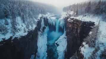 Majestic frozen waterfall in winter forest surrounded by snowy trees in misty landscape photo