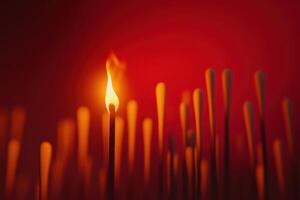 Glowing matchstick against red background illustrating ignition and heat in close-up photo