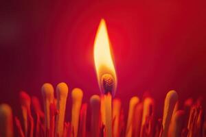 Burning matchstick with flame against red background symbolizing ignition and heat photo