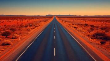 Endless open road through desert landscape at sunset with orange hue and vast horizon photo