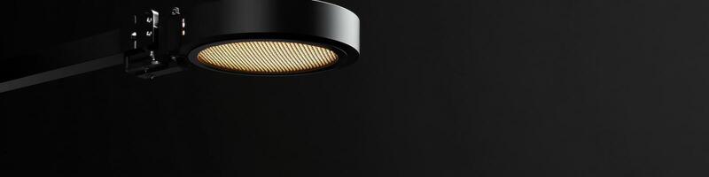 Black wall-mounted lamp with circular light fixture on dark background photo