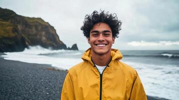 Young adventurer in jacket with backpack on rocky coast featuring ocean waves photo
