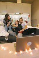 A group of friends enjoying a delightful and cozy movie night together in their home setting photo