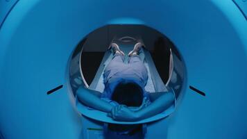 Anonymous Female Patient Lying on a CT, MRI Scan Bed Undergoes Scanning Procedure. Bed Moves Towards Camera. Precise diagnostics and internal organ visualization. Medical equipment computed tomography video