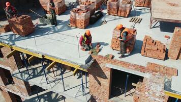 Aerial view Builders working on construction and laying bricks. Bricklaying of a brick multi-storey building video