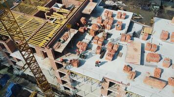Flight over the construction of a multi-storey building. Builders build a house of brick and concrete flooring. video