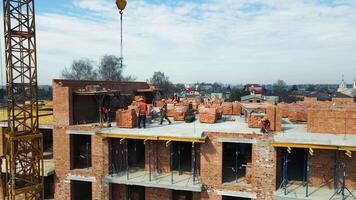 Flight over the construction of a multi-storey building. Builders build a house of brick and concrete flooring. video