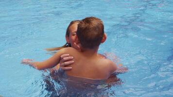 Mother and son playing in pool 4K video
