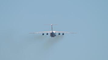 Heavy transport four engine aircraft climb after takeoff, rear view. Multipurpose turbofan strategic aircraft video