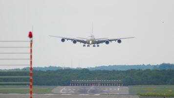 Front view of a four engine double deck wide body aircraft approaching landing, slow motion. Cinematic footage of a huge unrecognizable airliner flying. Airplane silhouette arriving at the airport video