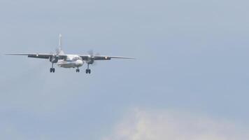 Transport turboprop aircraft approaching before landing at Novosibirsk airport. Soviet aircraft flies, long shot video