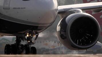 PHUKET, THAILAND FEBRUARY 24, 2023 - Close up of an airplane at taxiway. Chassis and engine. Airbus A330, OY VKJ of Sunclass Airlines taxiing at Phuket Airport. Tourism and travel concept video