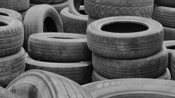 A large pile of old used tires in an auto repair shop where customers come in to replace their faulty tires. concept of recycling used tires or making good use of old tires. video