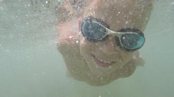Joyful child bathing and diving in the sea video