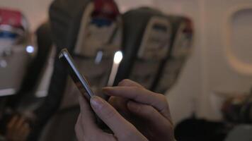 In plane sits girl and using mobile terminal on phone and pays for purchase through card video