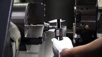 Quality control manufacturing,checks dimensions with vernier caliper at finish detail after metalworking on cnc machine. video