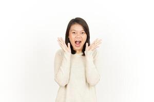 A woman is making a surprised face while standing in front of a white background photo