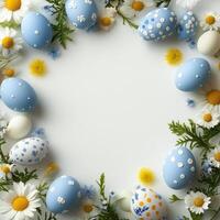 Spring frame of Easter eggs and delicate flowers on a light background with space for text in the middle. photo