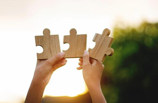 Wooden jigsaw puzzles show cooperation and teamwork, unity in working together. photo