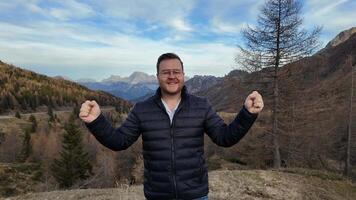 Smiling Caucasian man in a black jacket enjoying a scenic mountain view, ideal for adventure and tourism themes video