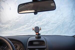 Nature drawings frost patterns on the windshield of a car at below zero air temperature, view from inside the car on an abstract winter pattern, photo