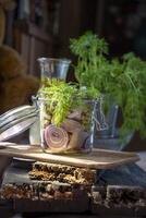 A jar of herring with onions marinated in mustard-vinegar sauce with dill and green peas on a table in the rays of the sun from the window, still life food photo, photo
