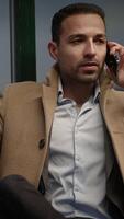 A professional man engaging in phone conversation while commuting through a busy city video