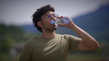 A Young Man is Hydrating Himself While Enjoying the Beautiful Scenery of Nature All Around Him video