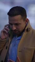 A man engaging in a telephone conversation while dressed in fashionable and stylish outerwear video