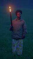 A mysterious figure is seen holding a flickering torch within a twilight field setting video