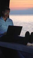 Engaging in work activities while enjoying the stunning seaside views at sunset video