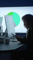 A focused professional is diligently analyzing data on a tablet in a modern workspace environment video