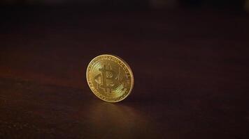 A Golden Coin is Spinning on a Beautiful Wooden Surface, Reflecting Its Shiny Appearance video