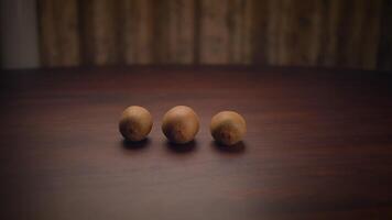 Three Beautiful Brown Nuts Displayed on a Rustic Wooden Table for a Charming Aesthetic video