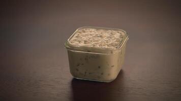 A Delicious and Creamy Dip Served in a Square Container, Enhanced with Fresh Herbs video