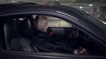 A mysterious figure sits in a car at night in a dark parking garage, creating intrigue video