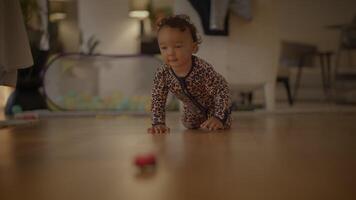 A curious little baby is happily crawling towards an enticing toy on the floor, exploring video