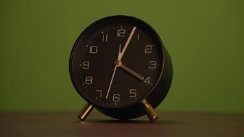 A Minimalist Black Alarm Clock Set Against a Striking Green Background, Perfect for Any Setting video