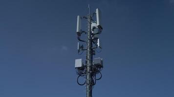 A telecom tower stands against a clear blue sky, showcasing its importance in communication video