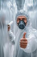 A man in a protective suit and mask holding a paint brush photo