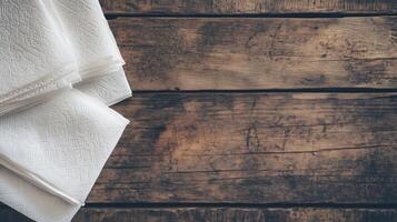 A set of folded white paper napkins with textured patterns placed on a rustic wooden table, creating a warm, vintage atmosphere, ideal for dining and hospitality themes photo