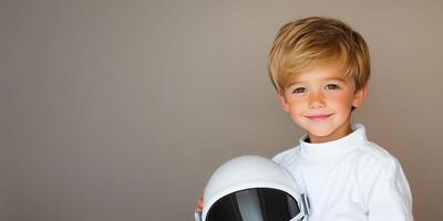 Smiling child in astronaut costume holding helmet against minimalist background. cosmonaut day photo