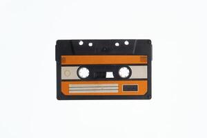 A vintage audio cassette tape with an orange and black label, isolated on a white background, evokes nostalgia and retro vibes. photo